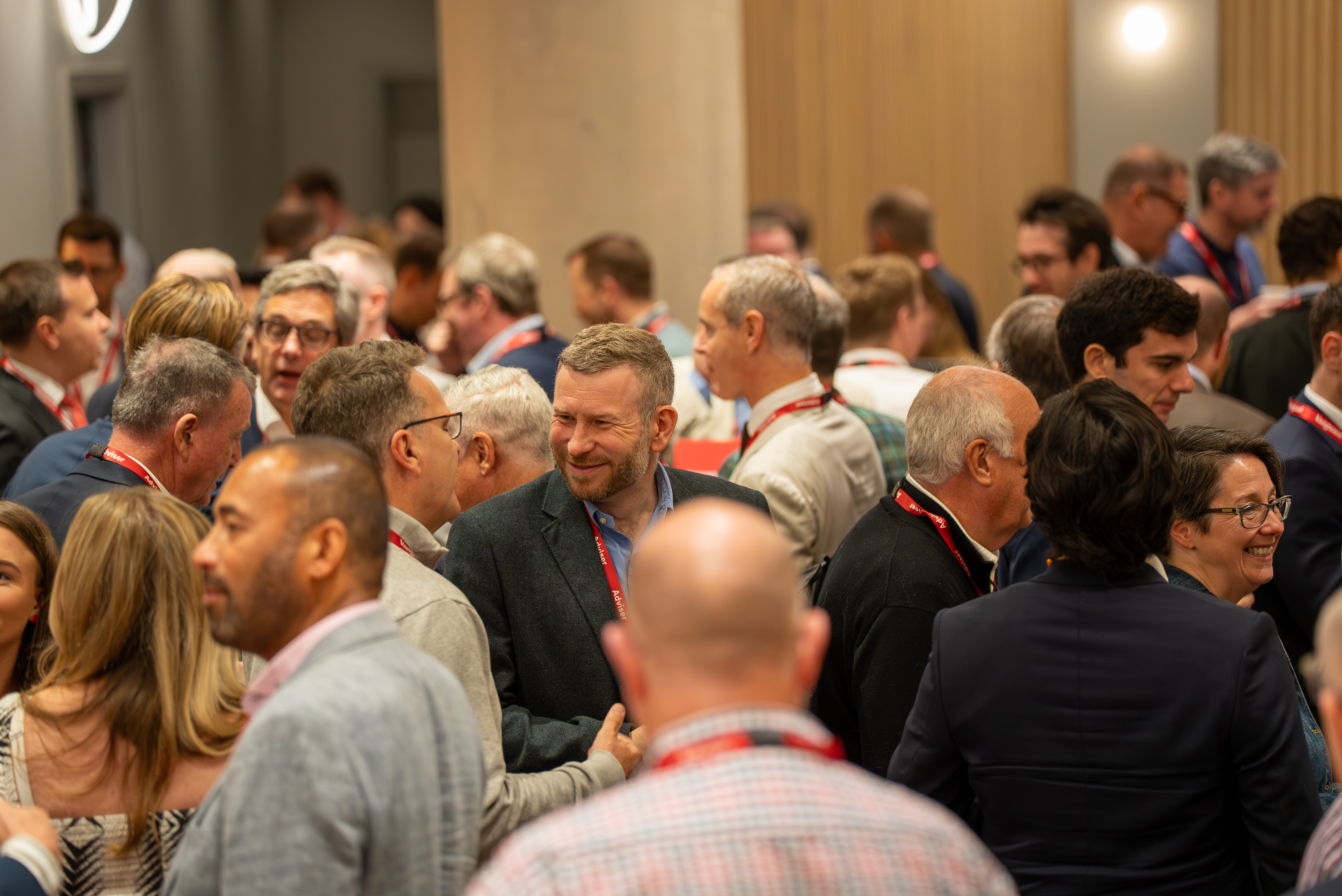 A busy room of conference attendees during a break