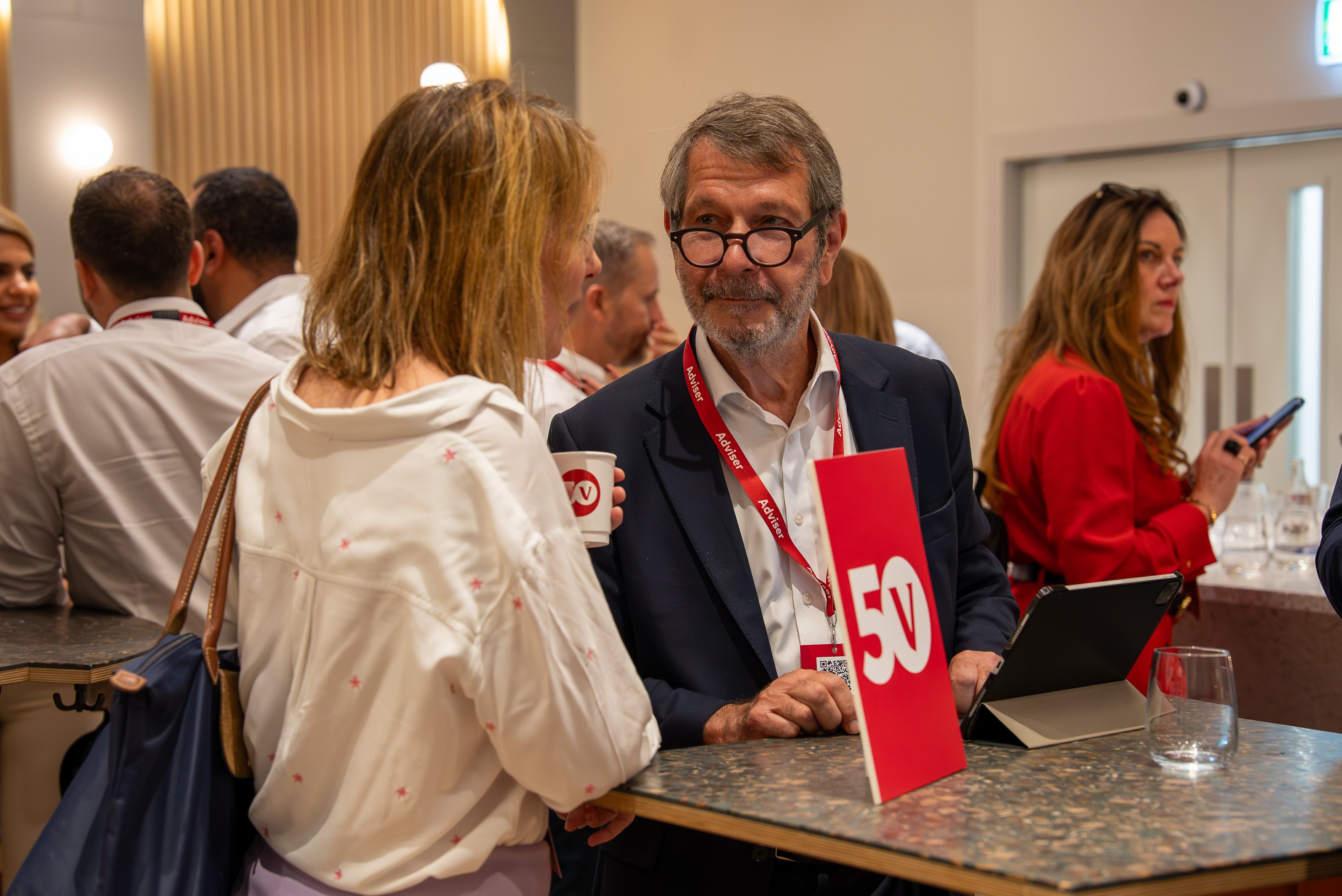 Two conference attendees talking at a table