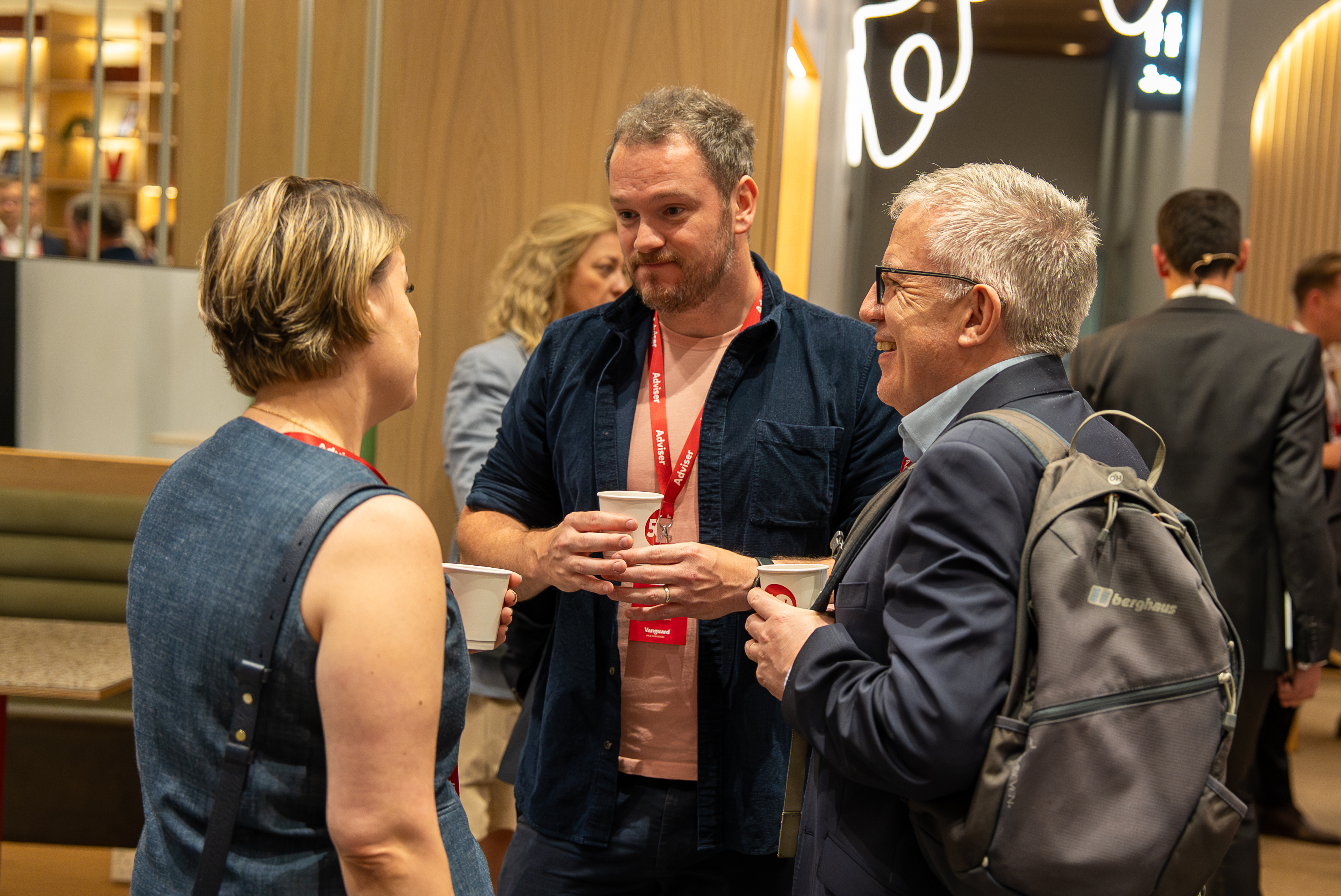 Three conference attendees drinking coffee during a break