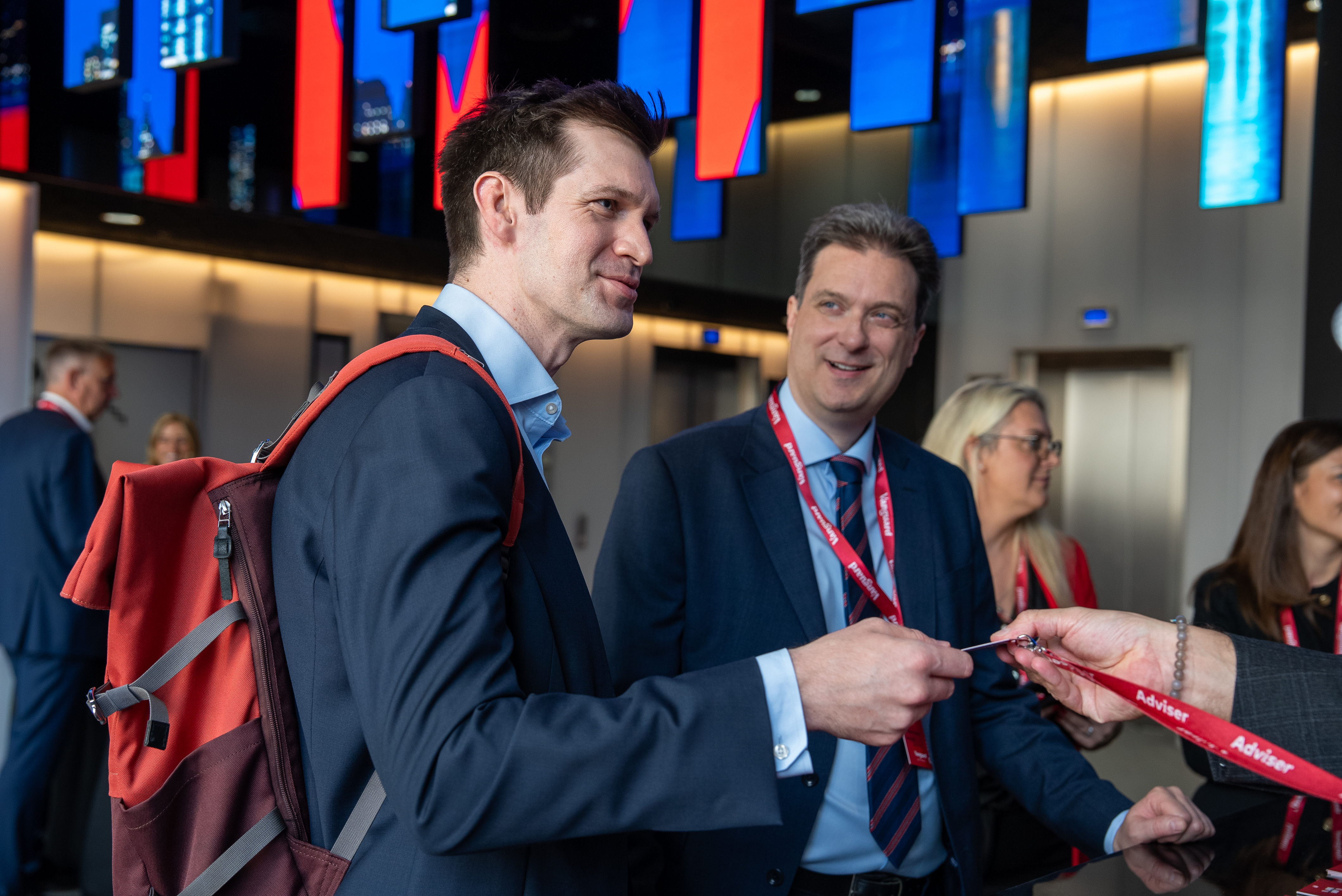 Two conference attendees receiving their passes at the check in desk