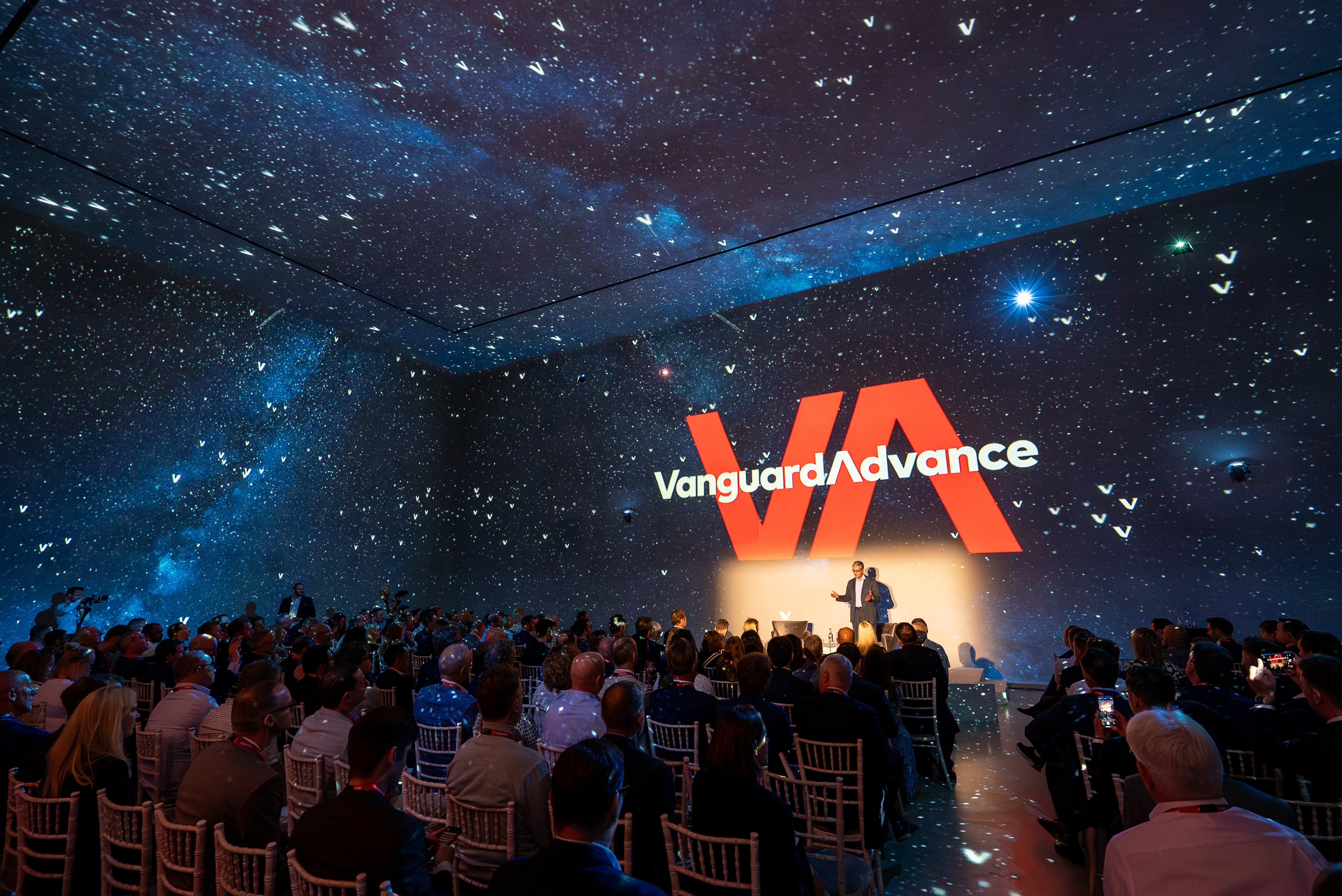 The conference stage at Vanguard Advance with Salim Ramji on stage speaking to the audience