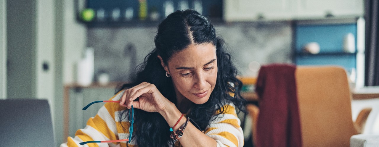  Woman reading while holding glasses